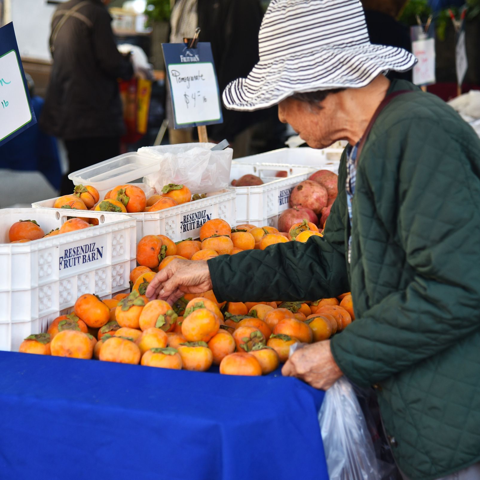 Resident picks fruit at farmers market.